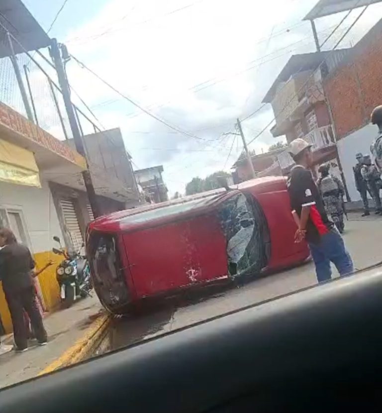 Vehículo estacionado vuelca tras ser «enganchado» y arrastrado por camión de carga, al oriente de Uruapan